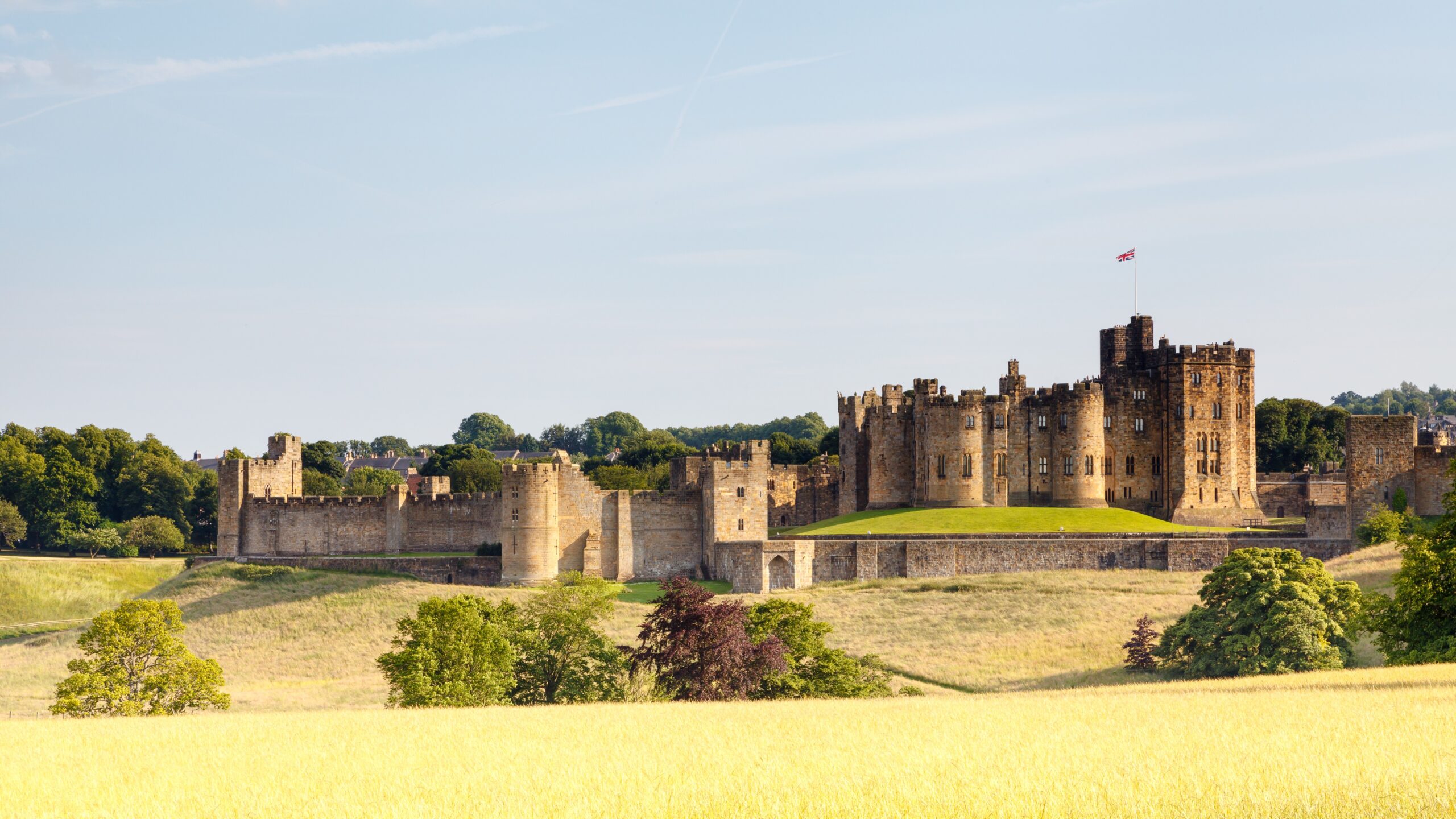 Alnwick Castle in Northumberland England with historic walls and countryside landscape